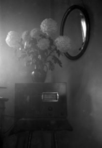 A vintage negative of a vase of flowers, radio and mirror found in an old contact printing frame